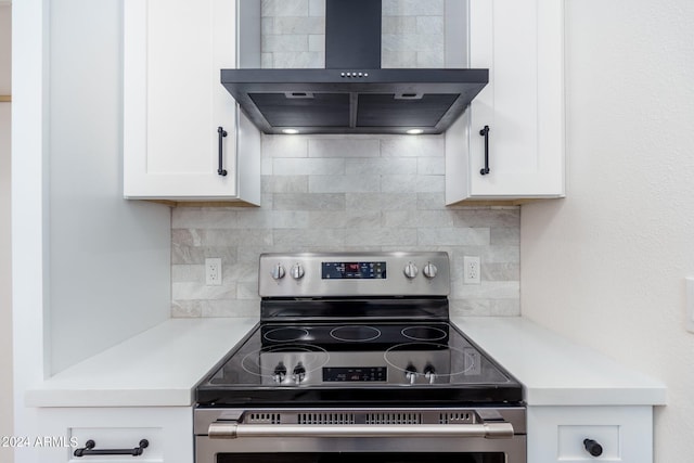 kitchen featuring decorative backsplash, ventilation hood, white cabinetry, and stainless steel range with electric cooktop