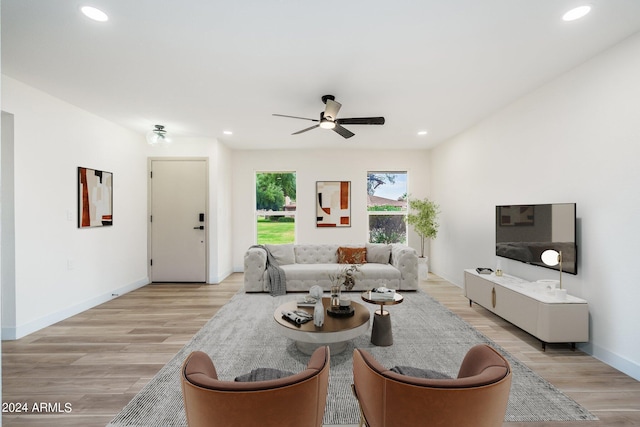 living room featuring light hardwood / wood-style flooring and ceiling fan