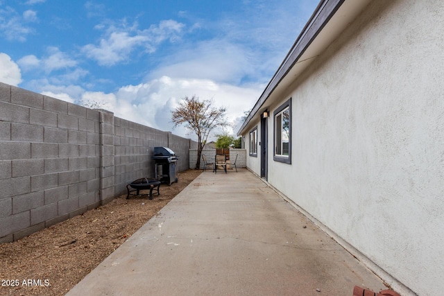 view of home's exterior featuring a fire pit, a patio area, a fenced backyard, and stucco siding