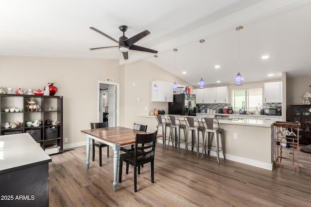 dining space featuring vaulted ceiling with beams, ceiling fan, baseboards, recessed lighting, and wood finished floors