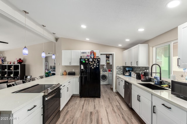 kitchen featuring washer / clothes dryer, vaulted ceiling with beams, a sink, range with electric stovetop, and black fridge