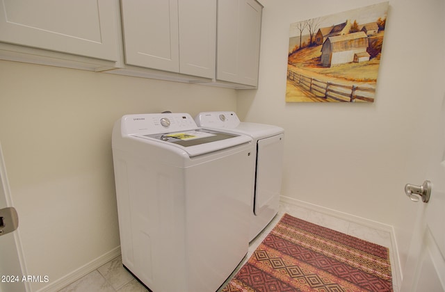 washroom featuring light tile patterned flooring, washer and dryer, and cabinets