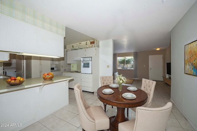 kitchen with white oven, white cabinetry, light tile patterned floors, and stainless steel electric stovetop