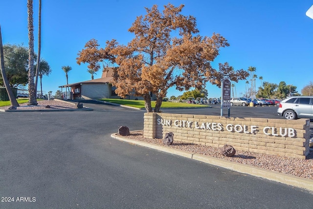 view of home's community with view of golf course and a lawn