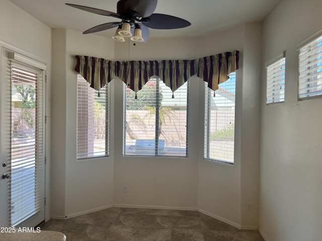 spare room with ceiling fan and baseboards