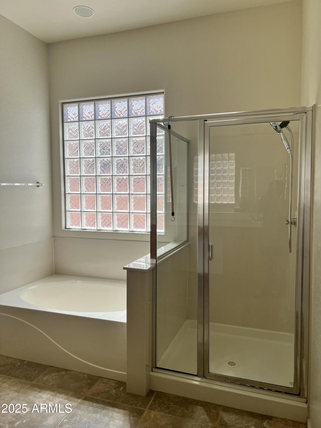 bathroom featuring a shower stall and a bath