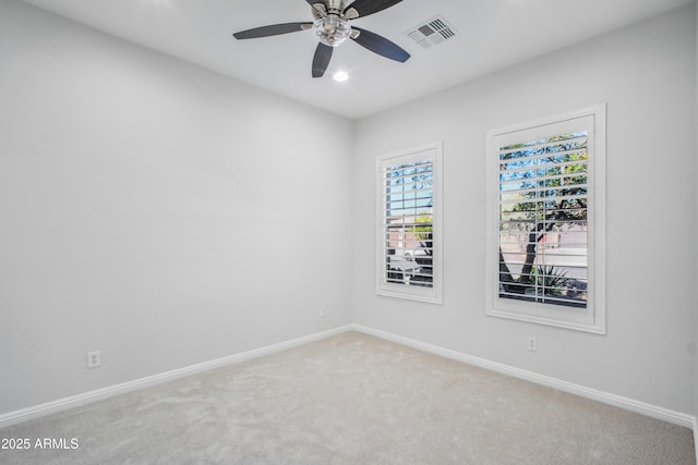 carpeted spare room featuring ceiling fan