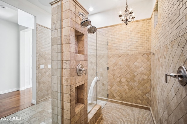 bathroom featuring tiled shower and a notable chandelier