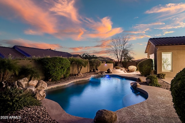 pool at dusk featuring a patio area