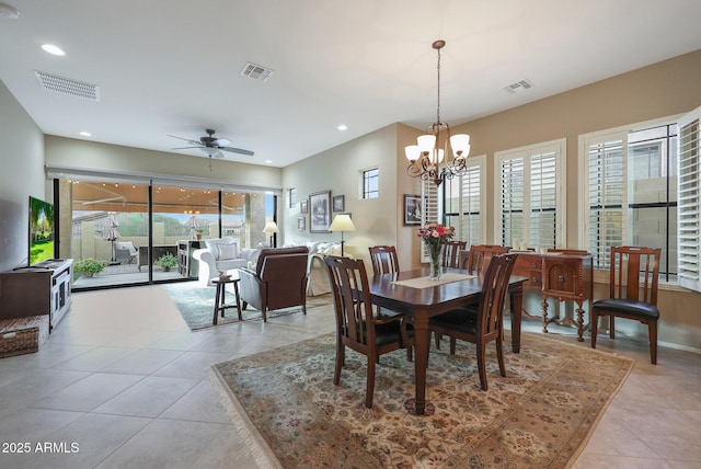 dining area with light tile patterned floors and ceiling fan with notable chandelier