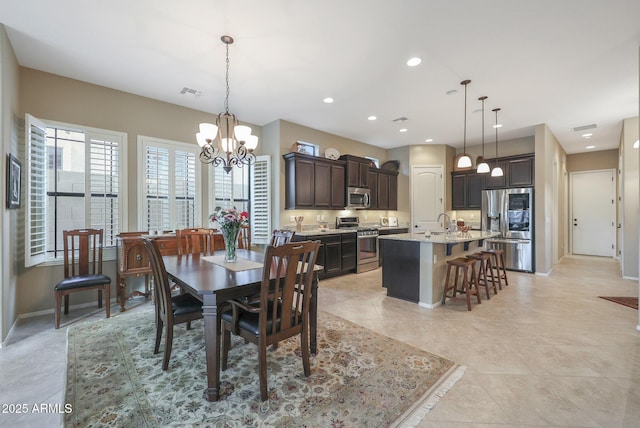 dining area featuring light tile patterned floors, a notable chandelier, and sink