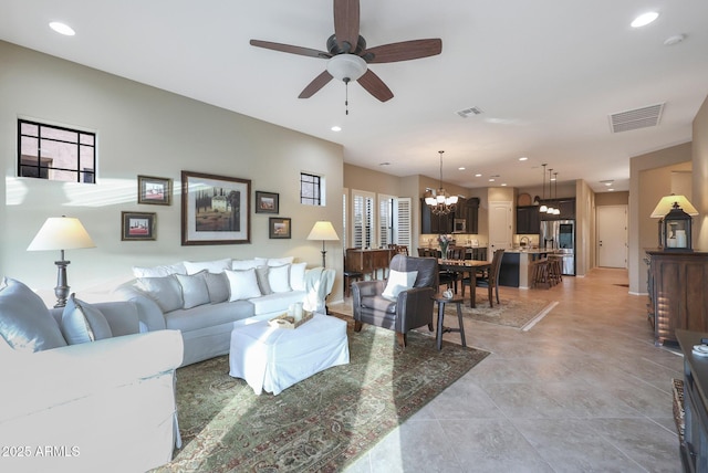 living room with ceiling fan with notable chandelier