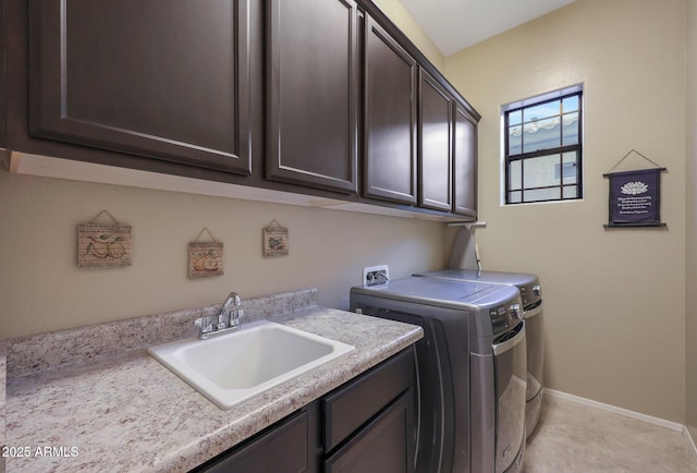 clothes washing area with cabinets, sink, and washing machine and clothes dryer