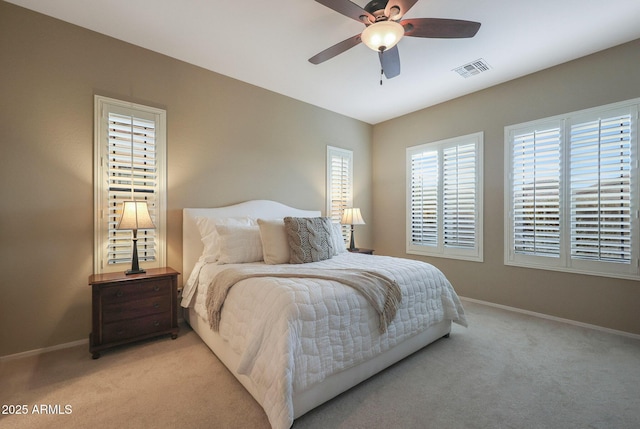 bedroom featuring multiple windows, light colored carpet, and ceiling fan