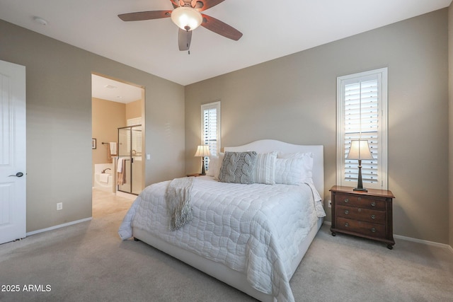 bedroom with multiple windows, light colored carpet, ceiling fan, and ensuite bathroom