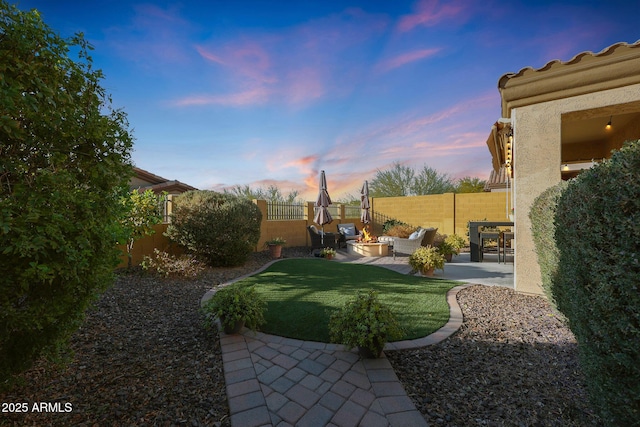 yard at dusk with outdoor lounge area and a patio area