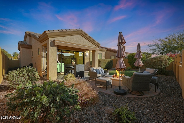 back house at dusk with a patio area and an outdoor living space