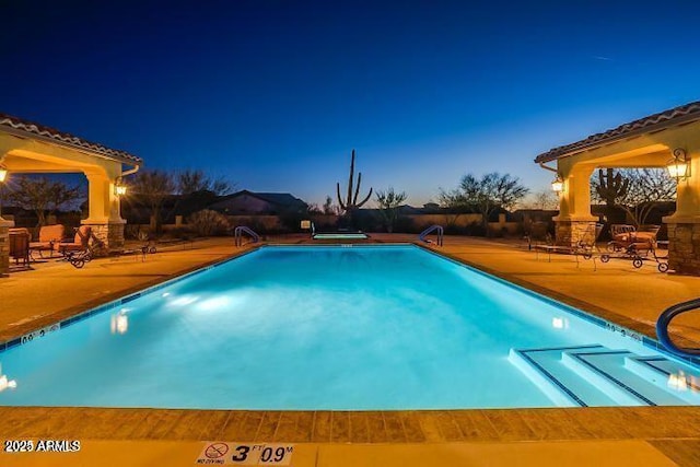 pool at dusk featuring a patio area