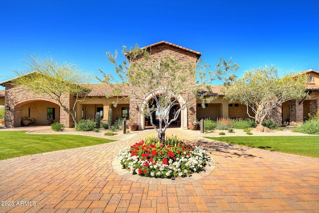 mediterranean / spanish home with a front lawn