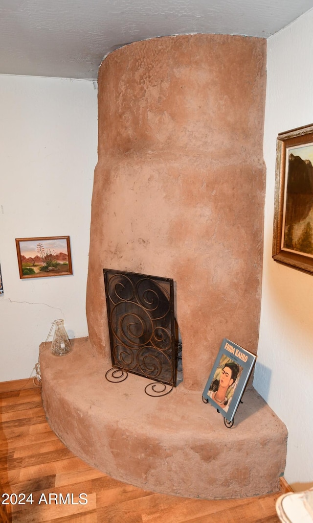 room details featuring a large fireplace and hardwood / wood-style flooring