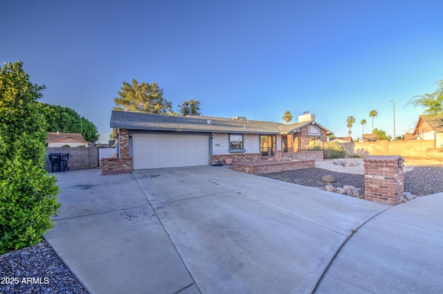 ranch-style house with driveway, a chimney, fence, brick siding, and a garage