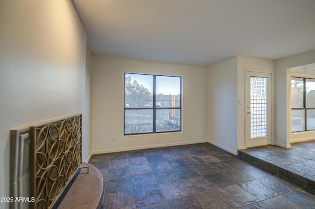 interior space featuring stone tile flooring and baseboards
