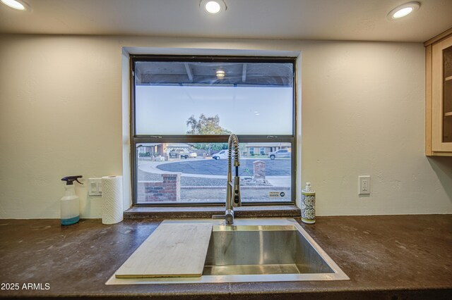 interior details featuring dark countertops, recessed lighting, glass insert cabinets, and a sink