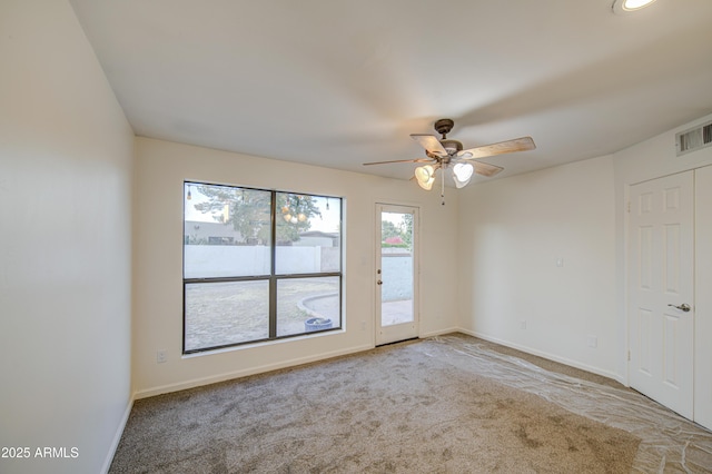 empty room with baseboards, visible vents, a ceiling fan, and carpet floors