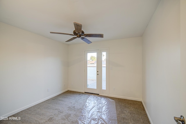 empty room featuring baseboards, a ceiling fan, and carpet