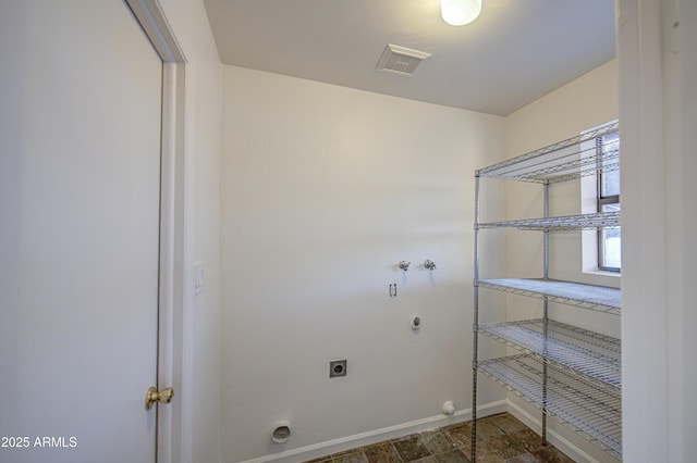 clothes washing area with laundry area, hookup for an electric dryer, hookup for a gas dryer, baseboards, and visible vents