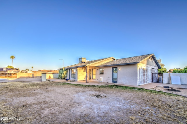 rear view of house featuring fence, a gate, and a patio area