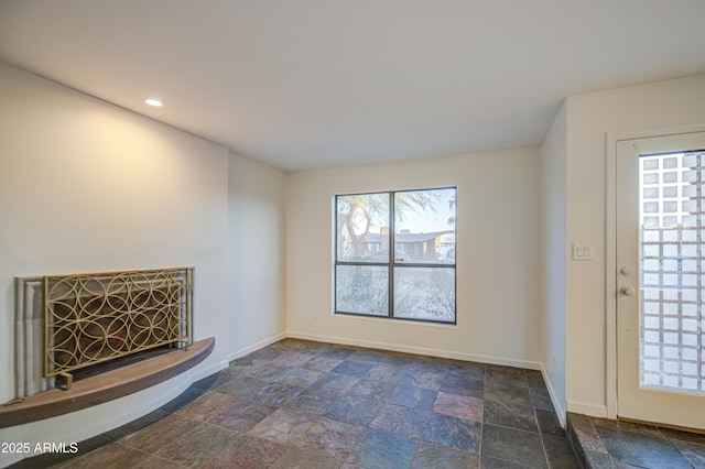 unfurnished living room featuring recessed lighting, baseboards, and stone finish flooring