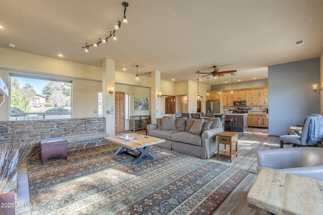 living room featuring ceiling fan, a textured ceiling, and hardwood / wood-style flooring