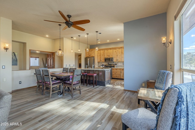 dining room with ceiling fan and light hardwood / wood-style floors