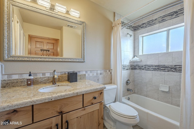 full bathroom with shower / bathtub combination with curtain, tile walls, vanity, and toilet