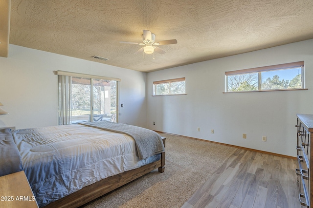 bedroom with multiple windows, ceiling fan, access to outside, and light wood-type flooring