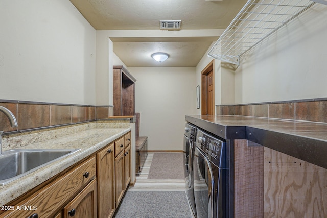 kitchen with washer and dryer, a textured ceiling, and sink