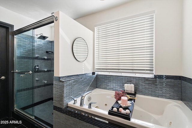 bathroom featuring a stall shower and a whirlpool tub