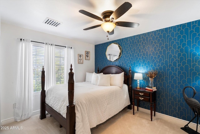 carpeted bedroom with baseboards, an accent wall, visible vents, and wallpapered walls