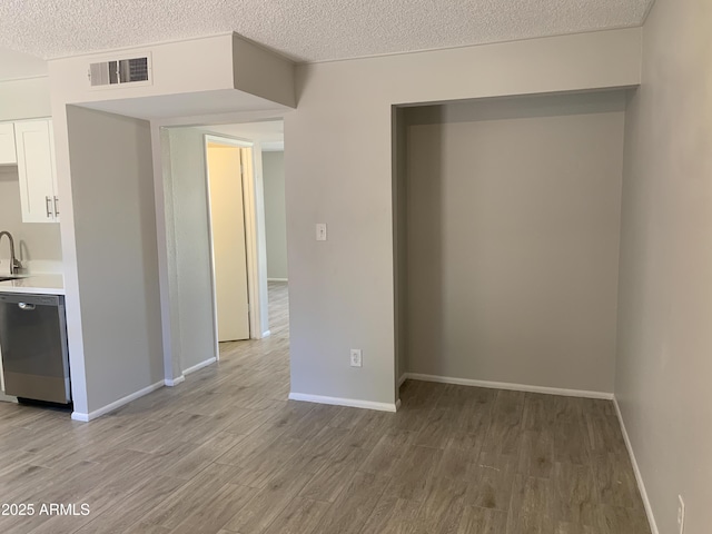2155 W Farmdale Ave Unit 8, Mesa, AZ 85202 - kitchen featuring dishwasher, light wood-style flooring, white cabinets, light countertops, and a textured ceiling