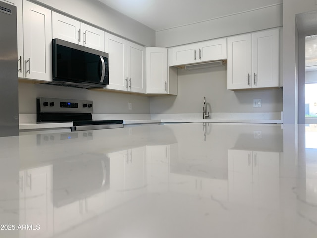 2155 W Farmdale Ave Unit 8, Mesa, AZ 85202 - kitchen with appliances with stainless steel finishes, white cabinetry, and a sink