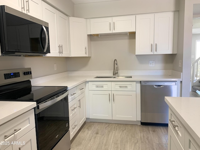 2155 W Farmdale Ave Unit 8, Mesa, AZ 85202 - kitchen featuring appliances with stainless steel finishes, a sink, light countertops, and white cabinetry