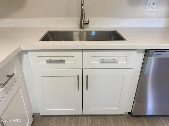 2155 W Farmdale Ave Unit 8, Mesa, AZ 85202 - kitchen view of stainless steel dishwasher, a sink, white cabinets, and light stone counters