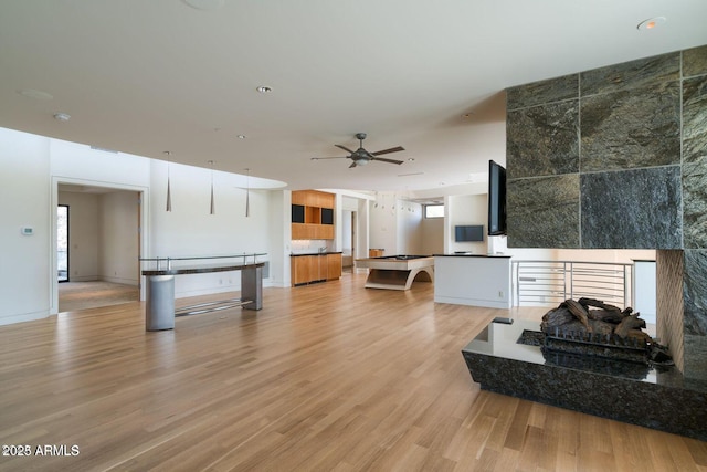 living room featuring a ceiling fan and light wood-type flooring