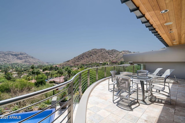 balcony with outdoor dining area and a mountain view