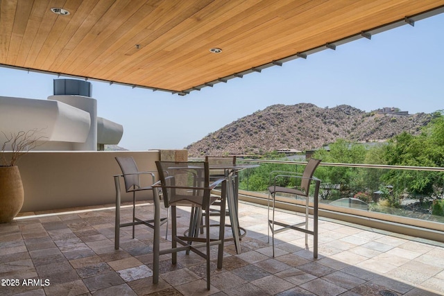 view of patio with a mountain view and a balcony