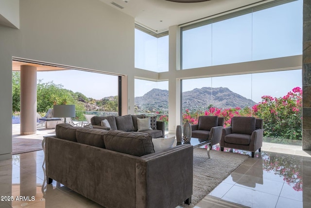 living area featuring visible vents, a high ceiling, a mountain view, and tile patterned floors