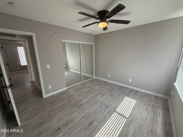2429 E Alameda Dr, Tempe, AZ 85282 - unfurnished bedroom featuring wood finished floors, visible vents, a closet, baseboards, and multiple windows