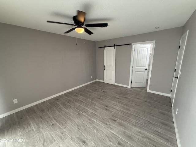 2429 E Alameda Dr, Tempe, AZ 85282 - unfurnished bedroom with baseboards and a barn door