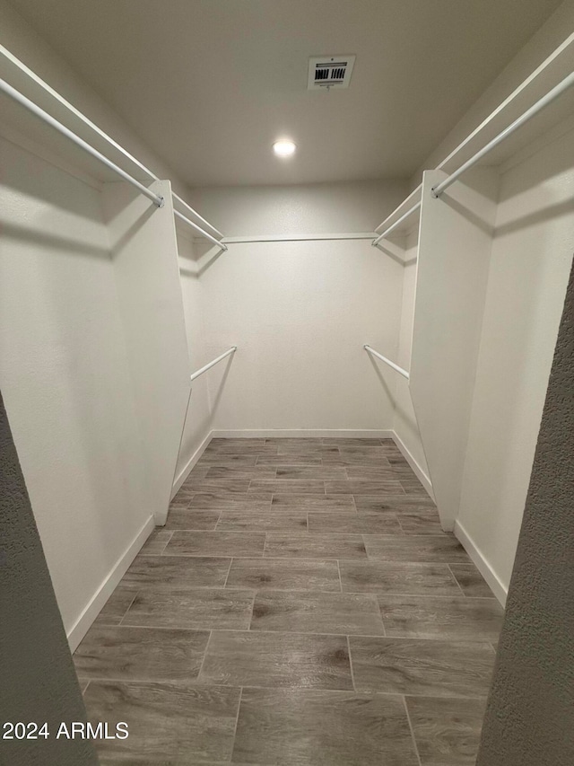 walk in closet with hardwood / wood-style floors